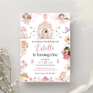 May include: A whimsical invitation for a birthday party, featuring a fairy theme. The design includes illustrations of fairies, flowers, and a fairy house. The text reads "To Celebrate The Birthday Girl Estelle Is Turning One".