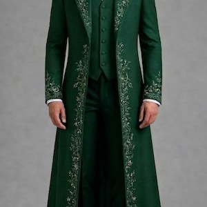 May include: A dark green formal suit with silver embroidery. The suit comprises a long coat, waistcoat, and trousers. The coat has detailed floral patterns along the edges. A white dress shirt is visible beneath the waistcoat. Black dress shoes complete the ensemble.