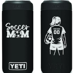 May include: Black insulated can cooler with a silver top. One side features the words "Soccer Mom" with a soccer ball graphic. The other side shows a soccer player with customizable text and number.
