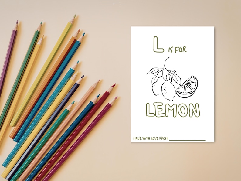 May include: A white rectangular coloring page featuring a line drawing of two lemons on a branch and a lemon slice. The text reads L IS FOR LEMON and MADE WITH LOVE FROM. A collection of multi-colored sharpened pencils is arranged to the left.