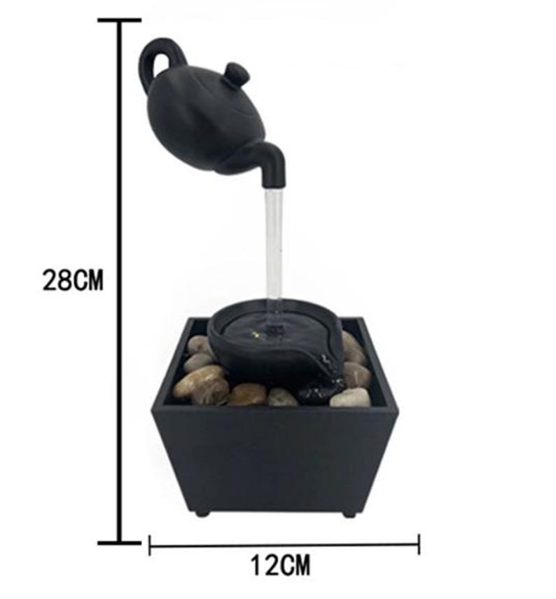 May include: A black tabletop water fountain with a teapot design. The fountain features a teapot pouring water into a small basin, which then flows into a square base filled with stones. The fountain is 11 inches tall and 4.7 inches wide.
