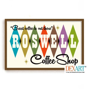 Puede incluir: Un letrero de estilo retro para una cafetería llamada "Roswell Coffee Shop". El letrero presenta el texto "Great coffee is out there" entre comillas y el nombre de la tienda en un patrón de diamantes coloridos.