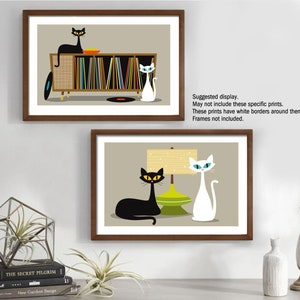 May include: Two framed illustrations of cats in a mid-century modern style. The top illustration features a black cat sitting on a record player with a white cat standing next to it. The bottom illustration features a black cat lying down next to a white cat and a lamp with a green base.