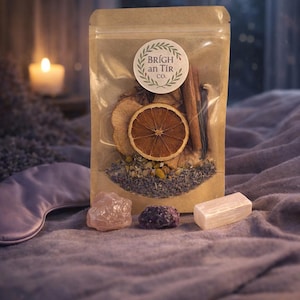 Può includere: Un sacchetto di carta kraft con frutta secca, erbe e spezie, etichettato "Brígh an Tír co.", è esposto con cristalli e una mascherina per dormire. Una candela accesa e la luna piena sono visibili sullo sfondo, creando un'atmosfera rilassante.