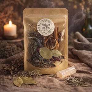 Puede incluir: Una bolsa de papel kraft llena de hierbas secas, especias y botánicos, etiquetada como "Brígh an Tír co.". Una vela encendida y un cristal de selenita están en primer plano. El fondo es una escena borrosa de tonos cálidos.