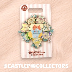 May include: A colorful enamel pin featuring Duffy and Friends characters. The pin is on a white card with pink stripes and the Shanghai Disney Resort logo. The pin includes the text "DUFFY AND FRIENDS".