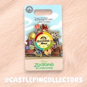 May include: A Zootopia pin featuring various characters from the Disney movie. The pin is on a light blue card with the Shanghai Disney Resort logo and the Zootopia logo. The pin has a circular design with the Chinese characters for Zootopia.