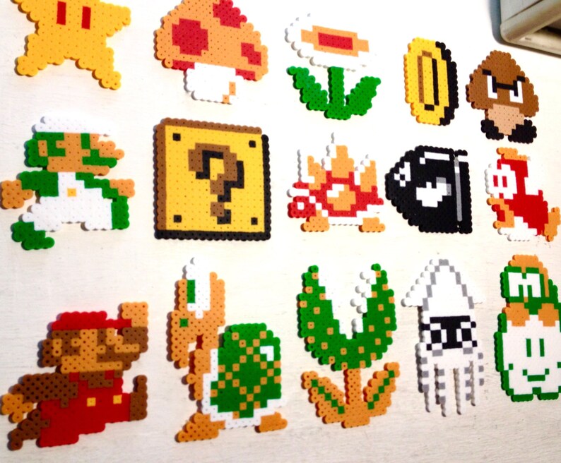 Puede incluir: Una colecci&oacute;n de personajes y objetos coloridos de pixel art de la serie de videojuegos Super Mario. Incluye a Mario, Luigi, una estrella, un hongo, una flor, una moneda, un Goomba, un bloque de interrogaci&oacute;n, un Koopa Troopa, un Bill Bala y m&aacute;s.