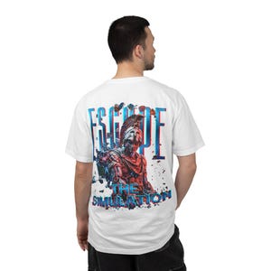 Puede incluir: Camiseta blanca con un diseño gráfico en la espalda. El diseño presenta un soldado romano con las palabras "ESCAPE THE SIMULATION" en letras 3D azules y rojas. La camiseta está hecha de un material suave.