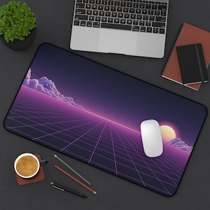 Puede incluir: Alfombrilla de ratón rectangular con un diseño retro, con una cuadrícula morada y rosa, nubes y un sol poniente. Un ratón blanco está sobre la alfombrilla, con un portátil, un cuaderno y una taza de café cerca.