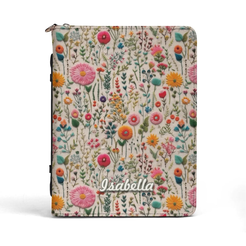 May include: A rectangular zippered planner cover featuring an off-white background with a colorful floral pattern of pink, yellow, orange, and blue wildflowers. The name Isabella is printed in a white script font near the bottom center of the cover.