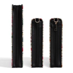 May include: Three rectangular cases of varying heights, each featuring a floral pattern with red, pink, and green tones. The cases have black side panels, black zippers, and metallic hardware attachments at the top for carrying straps.