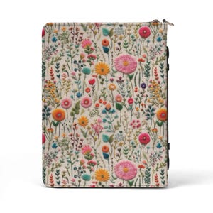 May include: A rectangular zippered case featuring an off-white fabric exterior with a dense, colorful embroidered pattern of various wildflowers, including pink, orange, yellow, and blue blossoms, along with green stems and leaves.