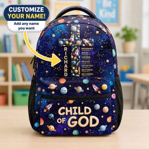 May include: A dark blue backpack featuring a space-themed pattern with planets, stars, and rockets. A cross design displays the name RICHARD and religious text. The front pocket features the text CHILD OF GOD in large, light-colored lettering.