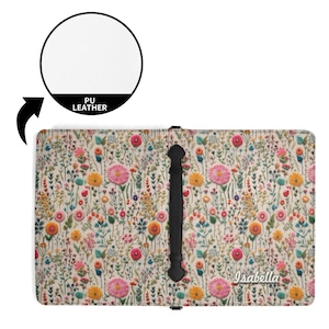May include: A rectangular PU leather cover featuring a colorful floral pattern with pink, yellow, and blue wildflowers on a cream background. A black vertical strap is centered on the front, and the name Isabella is printed in white script.