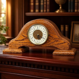 May include: A mantel clock with a curved wooden frame featuring a prominent oak grain pattern. The circular clock face has a white background with black Roman numerals, a decorative gold-toned center, and thin black metal hands for timekeeping.