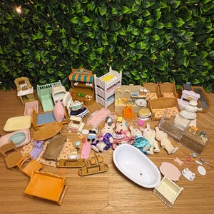 May include: A collection of miniature dollhouse furniture and accessories including a white bathtub, several small animal figures, beds, chairs, a food stand, and various household items like trays, tables, and kitchenware scattered across a surface.
