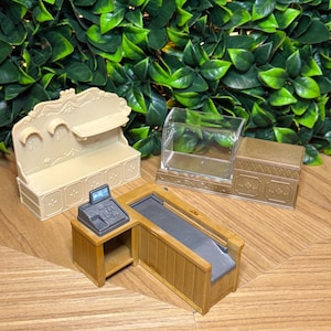 May include: A miniature retail set featuring a beige wall shelf unit with decorative molding, a clear plastic display case with a gold base, and a brown wooden checkout counter equipped with a small gray cash register and a conveyor belt.