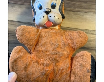 Juguete de peluche vintage con cara de goma y forma de perro, color naranja flocado, estilo mediados de siglo, tal cual se muestra.