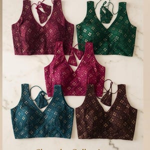 May include: Five sleeveless V-neck blouses in burgundy, emerald green, magenta, teal, and dark brown. Each blouse features a repeating geometric diamond pattern with metallic accents and includes matching tie-back straps. Text reads: Shop the Collection.