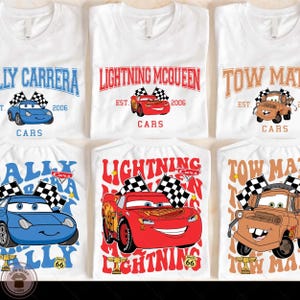 a collection of six white t-shirts featuring the characters Lightning McQueen and Towing Man from the animated movie Cars. The t-shirts display the characters in various poses, with the Lightning McQueen character prominently featured in each design.