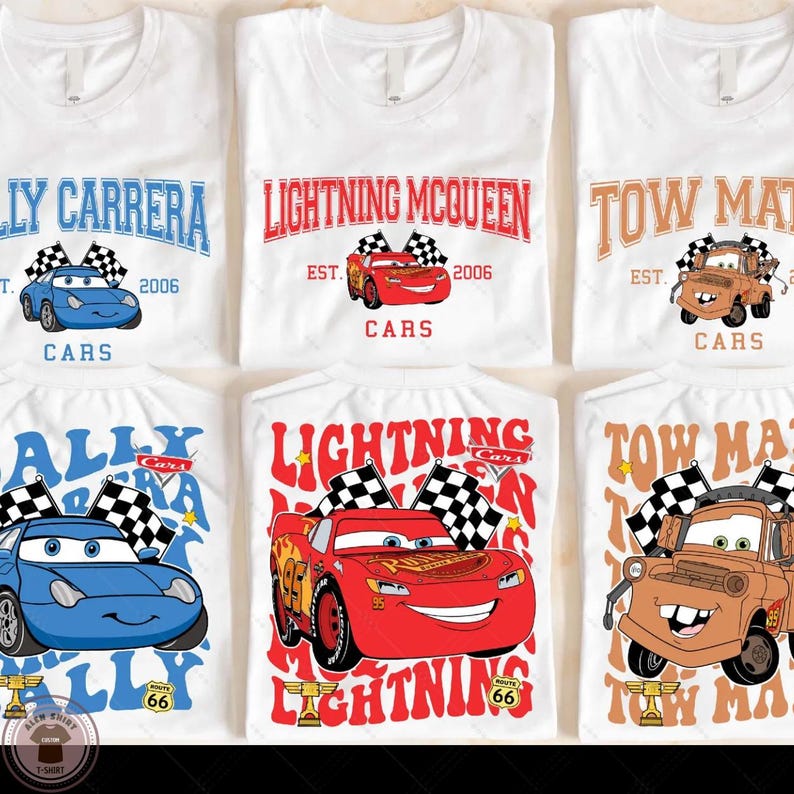 a collection of six white t-shirts featuring the characters Lightning McQueen and Towing Man from the animated movie Cars. The t-shirts display the characters in various poses, with the Lightning McQueen character prominently featured in each design.