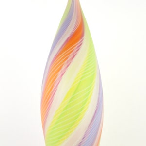 May include: A tall, teardrop-shaped glass vase with a spiraling design. The vase features bands of color including orange, yellow, green, purple, and white. The glass has a smooth, glossy finish and a pointed top.