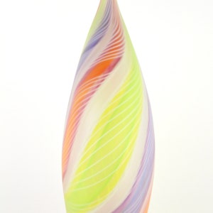May include: A tall, teardrop-shaped glass vase with a colorful, swirled design. The vase features bands of orange, purple, yellow, and white, with thin white lines. The vase has a smooth, glossy finish and a pointed top.