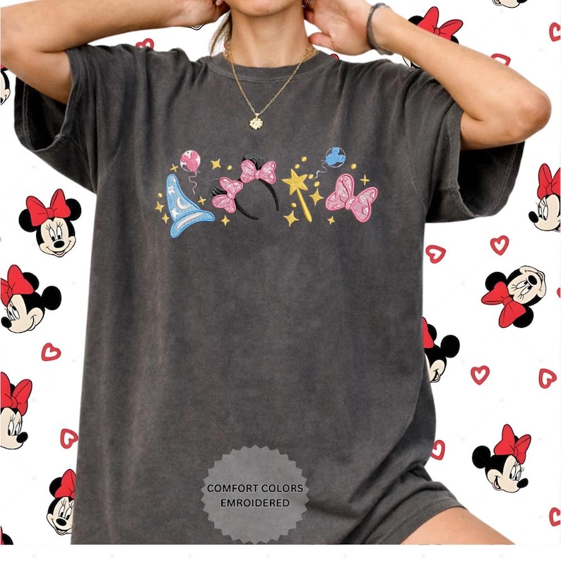 A person wearing a gray t-shirt with a graphic design featuring Minnie Mouse and other Disney characters.
