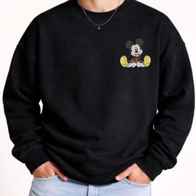 A person wearing a black sweatshirt with a cartoon character of Mickey Mouse printed on it.