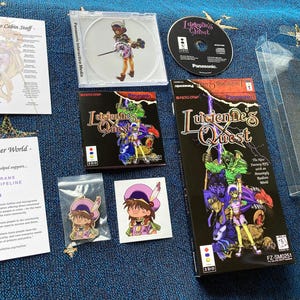 Peut inclure: Ensemble d'articles liés à "Lucienne's Quest", comprenant un CD, des boîtes de jeu, un étui en plastique transparent et des articles promotionnels. Les boîtes de jeu présentent des illustrations fantastiques colorées. Il y a aussi des feuilles imprimées avec du texte.