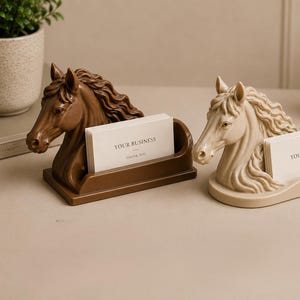 May include: Two horse head business card holders, one dark brown and one beige, each featuring a sculpted equine bust with a flowing mane and a rectangular slot containing white cards printed with the text YOUR BUSINESS THANK YOU.