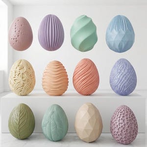 Op de afbeelding: Een verzameling decoratieve paaseieren in verschillende kleuren en texturen. De eieren worden op een wit oppervlak weergegeven en bevatten ontwerpen zoals kuiltjes, ribbels en geometrische patronen. Kleuren zijn onder meer roze, paars, groen en blauw.