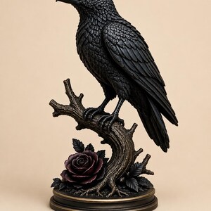 以下が含まれることがあります： 質感のある茶色の木の枝にとまった黒いカラスの置物。台座には緑の葉がついた濃い紫色のバラがあしらわれています。彫刻全体はブロンズ調の円形台座に取り付けられており、羽の質感が細部まで表現されています。