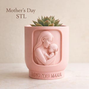 Może przedstawiać: Różowa ceramiczna donica z płaskorzeźbą matki i dziecka, trzymająca sukulenta. Donica ma napis "Mother's Day STL" i "LOVE YOU MAMA".