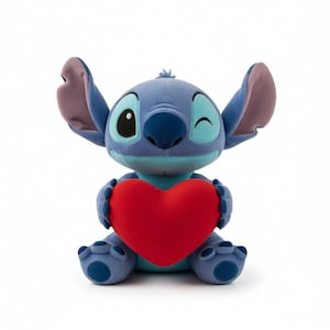 May include: A plush Stitch toy, in shades of blue, with large ears and a winking expression. The toy is holding a bright red heart. The overall design is a cute and friendly character.