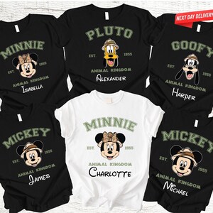 Może przedstawiać: Czarne i białe koszulki z postaciami Disneya Minnie, Pluto, Goofy i Mickey Mouse. Każda koszulka ma imię postaci, "Animal Kingdom" i imię poniżej. Jedna biała koszulka przedstawia Minnie Mouse.