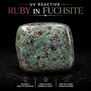 May include: A polished, square-shaped ruby in fuchsite stone featuring a mottled green and dark red pattern. The text above reads UV REACTIVE RUBY IN FUCHSITE, while the bottom text indicates it is natural, glows under UV light, and is hand polished.