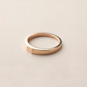 Könnte beinhalten: Ein einfacher Goldring mit leicht abgerundeter Kante.