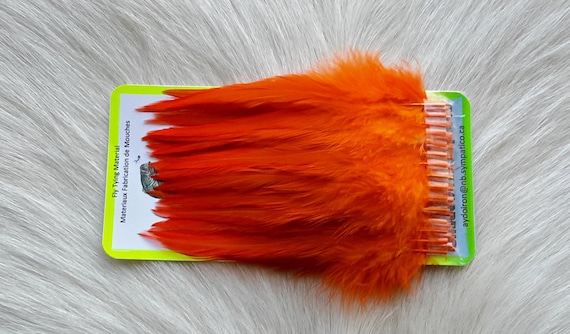 Fly Tying Feather. Select Schalpen Saddle Hackle (Feather)  (50) Per Plastic Bag. Color; . Orange.
