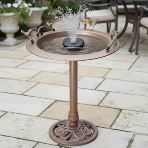 May include: A bronze-colored bird bath fountain with a water spray. The fountain has a round basin with decorative bird figurines around the rim. The base is a pedestal with an ornate, circular foot.