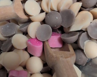 Perlas de cera derretida en una caja de plástico grande con cuchara de madera.