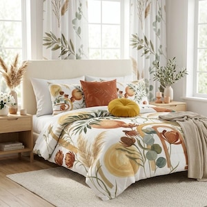 May include: A white comforter set featuring a botanical print with rust, yellow, and green leaves, flowers, and abstract shapes. The set includes a solid rust square pillow, a round mustard yellow pillow, and matching curtains with a leaf pattern.