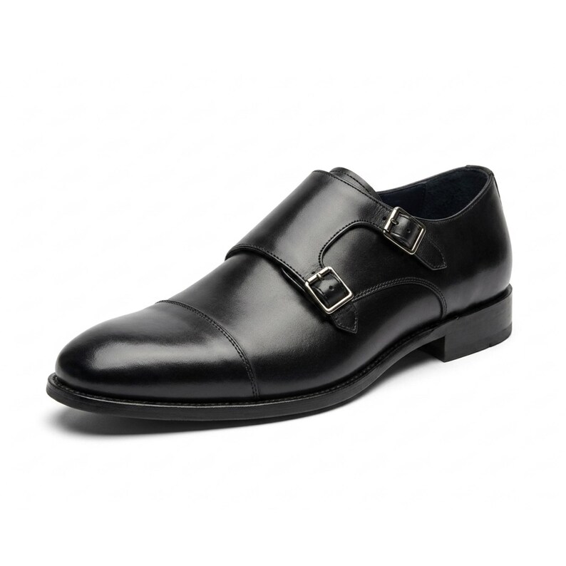 Puede incluir: Zapatos negros de cuero con doble hebilla. Estos zapatos tienen puntera y dos cierres de hebilla ajustables. El cuero est&aacute; pulido y las suelas son negras. Adecuados para vestimenta formal o de negocios. Miden aproximadamente 30 cm de largo.