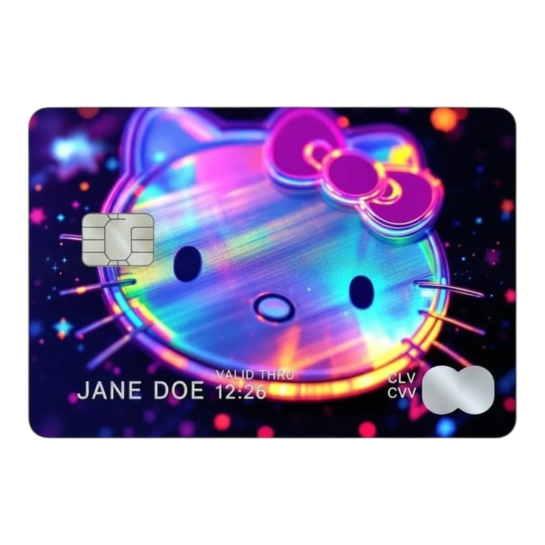 K&ouml;nnte beinhalten: Eine rechteckige Kreditkarte mit einem holografischen Hello Kitty-Gesicht mit violetter Schleife vor einem dunklen Hintergrund mit bunten Bokeh-Lichtern. Die Karte enth&auml;lt einen silbernen EMV-Chip, den Namen JANE DOE, den Text VALID THRU 12:26 und ein Logo.