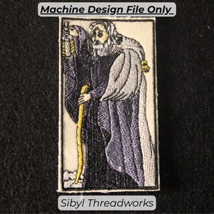 May include: Embroidered patch featuring a tarot card design. The image depicts a robed figure with a staff and lantern, rendered in shades of black, purple, and gold. Text at the top reads "Machine Design File Only_", and at the bottom, "Sibyl Threadworks."