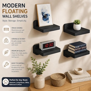 May include: Black floating wall shelves with various decorative items. The shelves display a framed abstract art piece, a small potted plant, a digital clock, and stacked books. The text on the image reads "MODERN FLOATING WALL SHELVES".