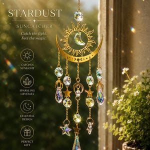 May include: A gold-colored suncatcher with a sun and crescent moon design, adorned with sparkling crystals and star-shaped charms. The text "STARDUST" and "SUNCATCHER" are visible, along with the phrases "Catch the light. Feel the magic."