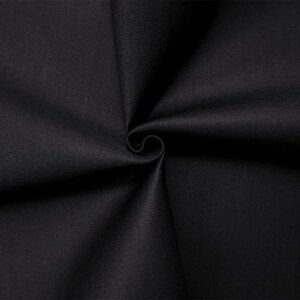 May include: Close-up of a swatch of black fabric, tightly swirled to show the texture and weave. The fabric appears to be a solid color, with a slight sheen, suggesting a high-quality material.