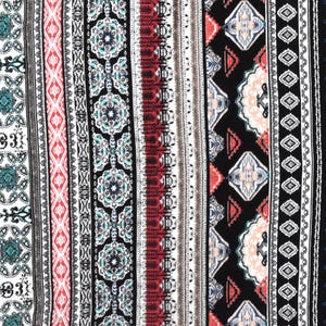 May include: A close-up of a fabric with a vertical striped pattern. The pattern includes stripes of black, white, red, and teal with geometric and floral designs. The fabric has a bohemian or ethnic aesthetic.